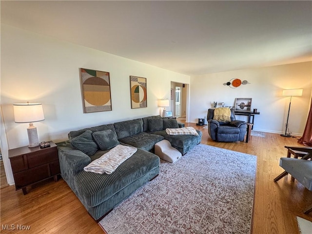 living area with baseboards and wood finished floors