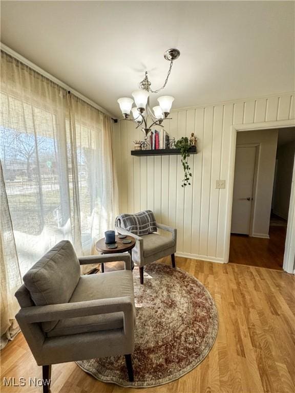 living area featuring light wood-style floors and a notable chandelier