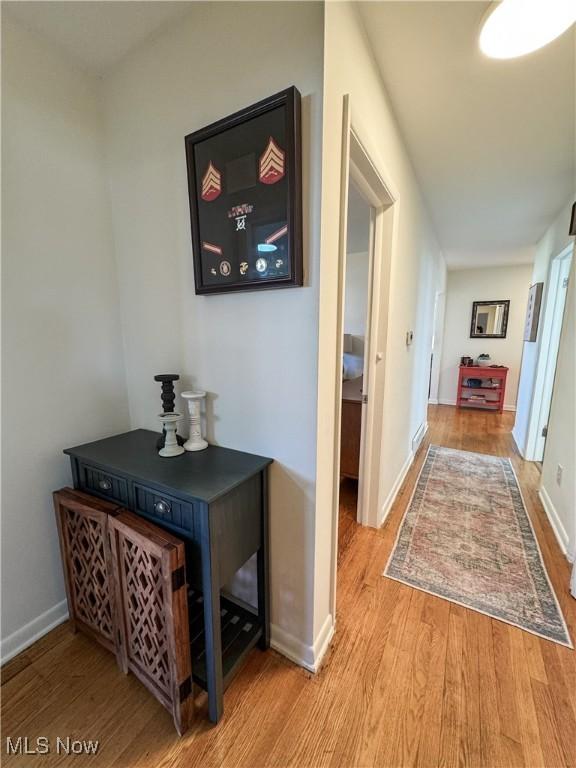 hallway featuring wood finished floors and baseboards