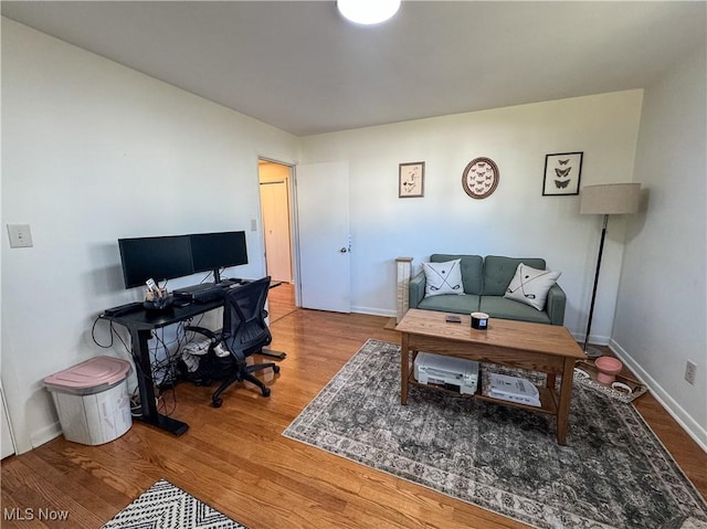 office space featuring baseboards and wood finished floors