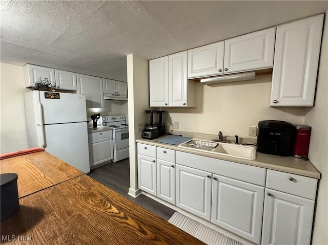 kitchen featuring white appliances, white cabinets, light countertops, a textured ceiling, and a sink