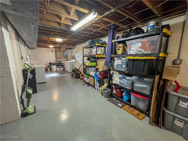 unfinished basement with concrete block wall and separate washer and dryer