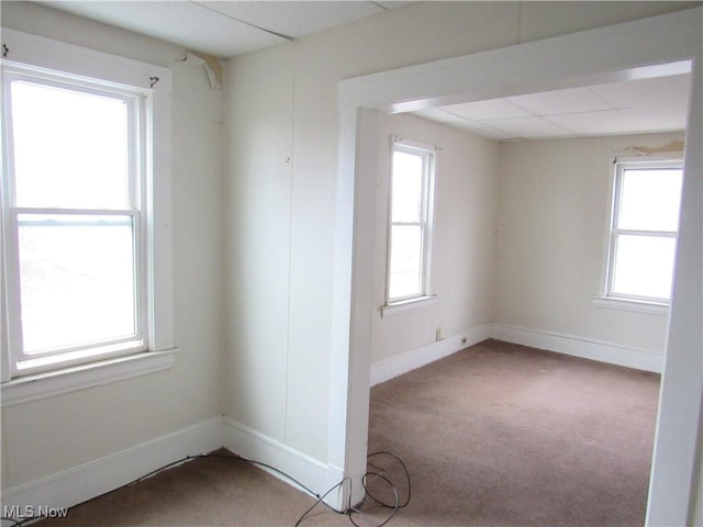 carpeted empty room with baseboards