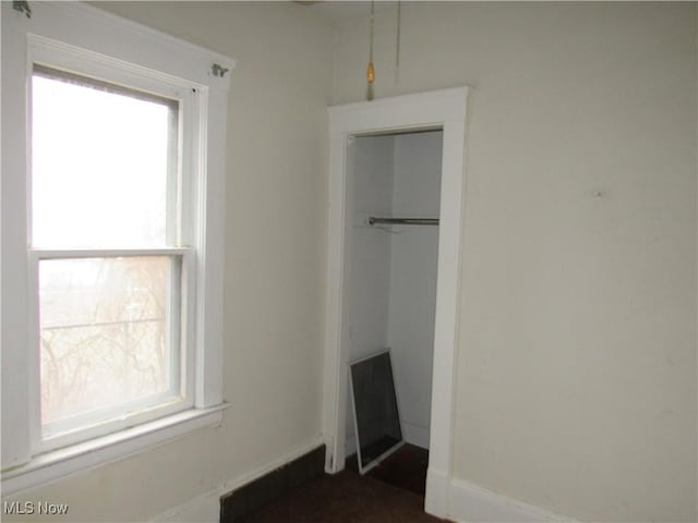 unfurnished bedroom with multiple windows and a closet