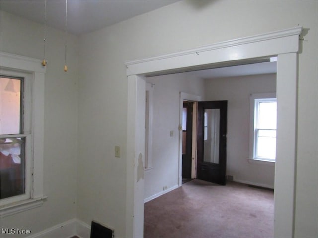 unfurnished room featuring carpet and baseboards