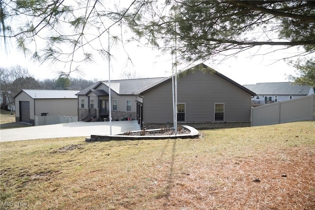 back of property featuring a yard, an outbuilding, and fence