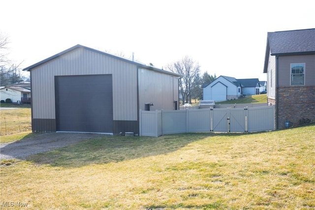 exterior space featuring driveway, a gate, fence, and an outdoor structure