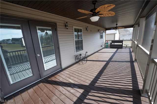 wooden deck with a ceiling fan and french doors