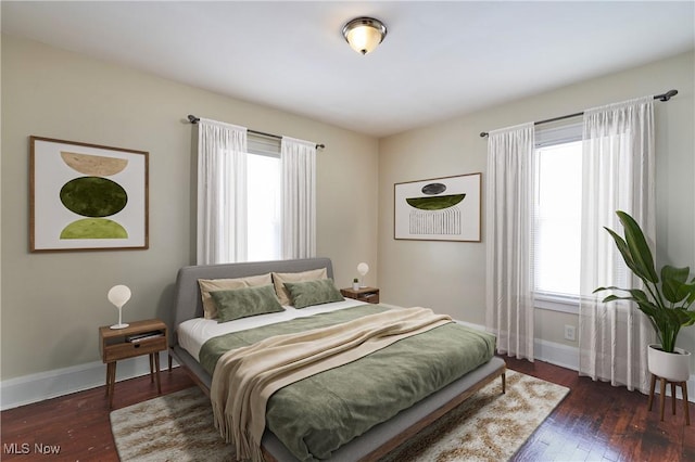 bedroom with hardwood / wood-style floors, multiple windows, and baseboards