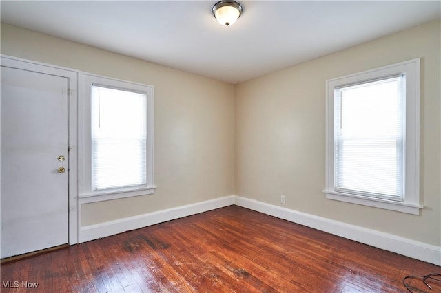 empty room with dark wood-style floors and baseboards