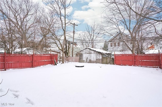 snowy yard with a fenced backyard