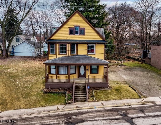 view of front facade with a porch, a front yard, and fence