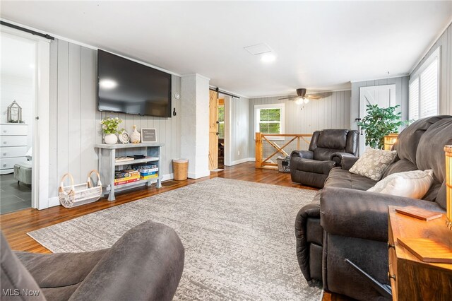 8950 County Road 292, Millersburg, OH 44654 - living room with ceiling fan, a barn door, wood finished floors, and baseboards