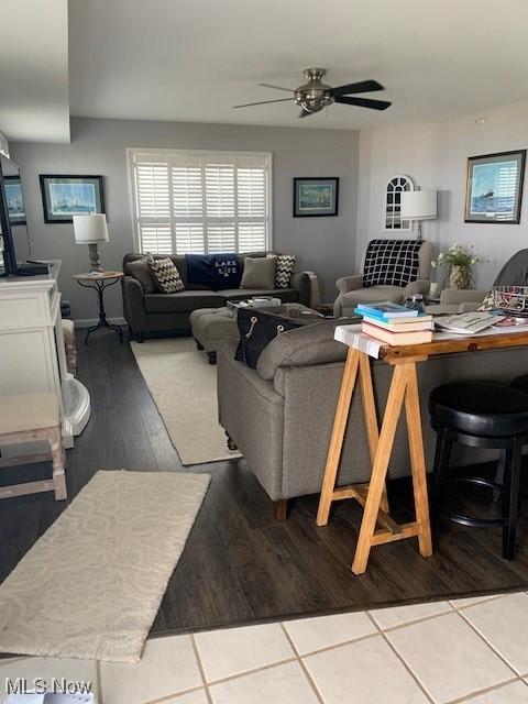 living area with ceiling fan and tile patterned floors