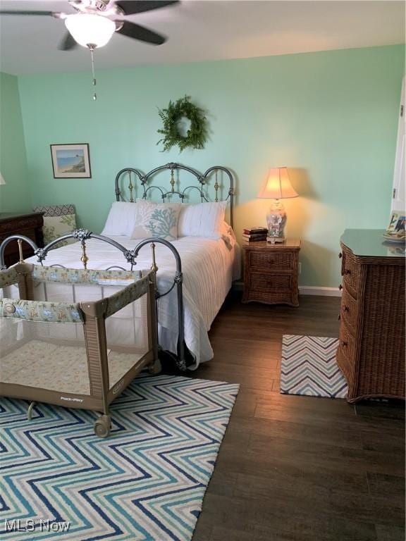 bedroom with ceiling fan, baseboards, and wood finished floors