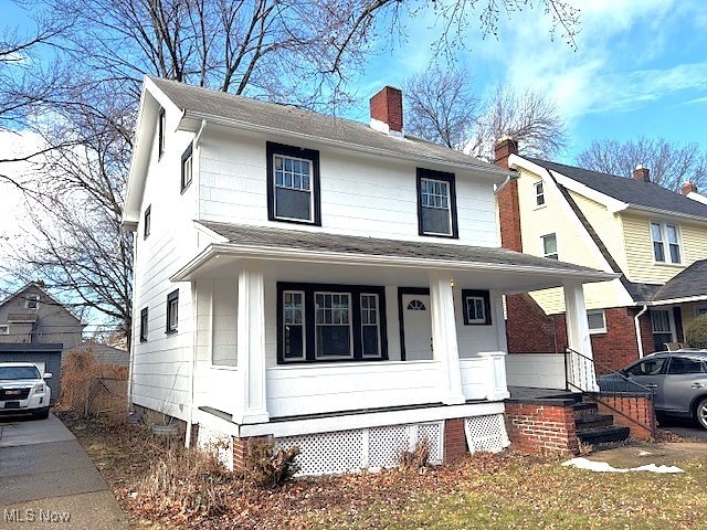 view of front facade featuring a chimney and a porch