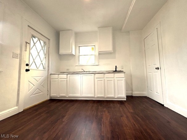 kitchen with dark wood-style floors, baseboards, and white cabinets