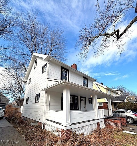 view of front of house featuring a porch and a chimney