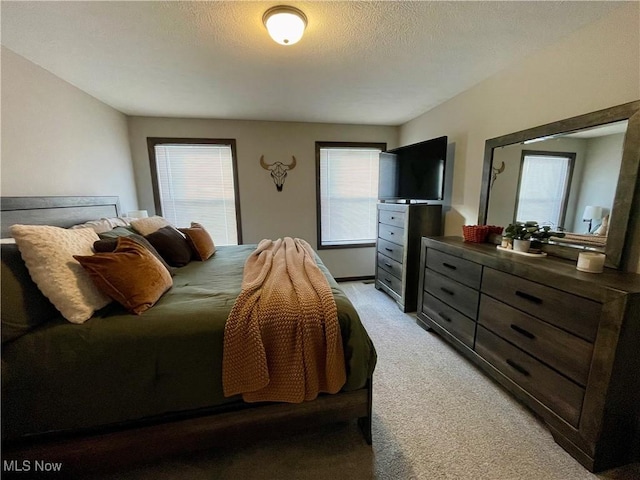 bedroom featuring light carpet and a textured ceiling