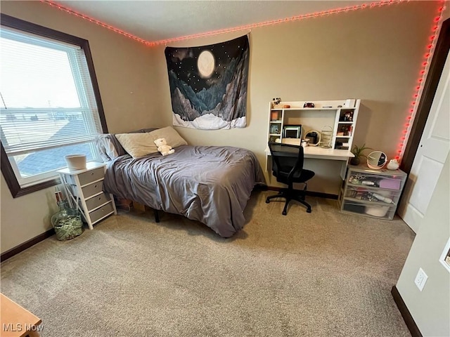 bedroom with carpet floors, multiple windows, and baseboards