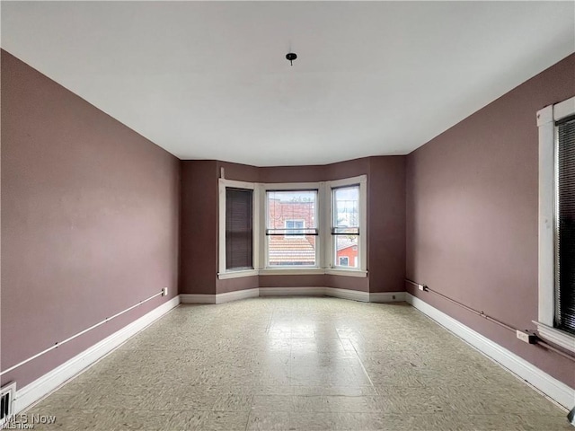 spare room featuring visible vents, baseboards, and tile patterned floors