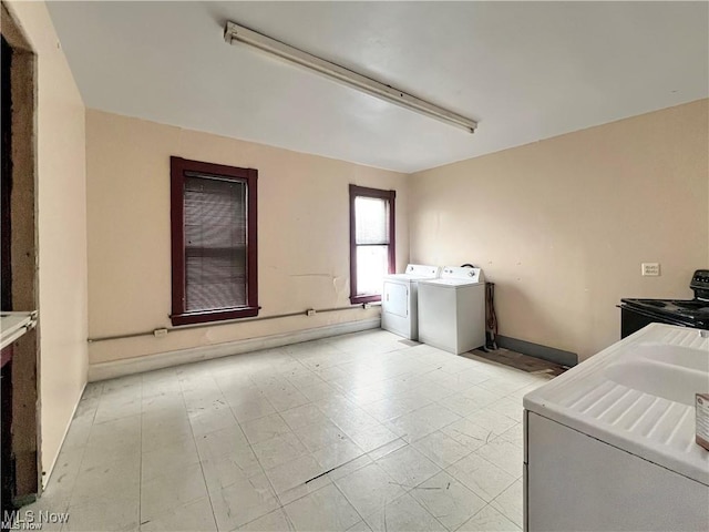 clothes washing area with laundry area, baseboards, and independent washer and dryer