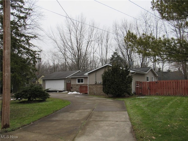 view of front of house featuring a garage, a front yard, brick siding, and fence