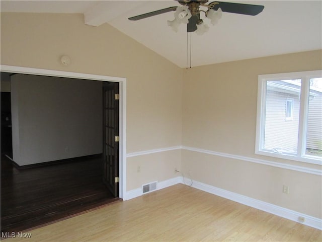 unfurnished room with baseboards, visible vents, a ceiling fan, wood finished floors, and vaulted ceiling with beams