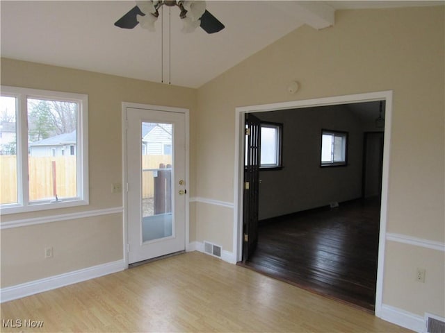 interior space featuring lofted ceiling with beams, wood finished floors, visible vents, and baseboards