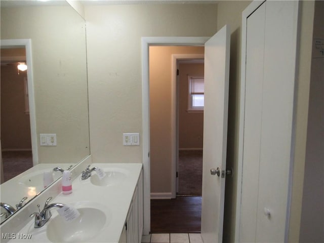 bathroom featuring double vanity, a sink, and tile patterned floors