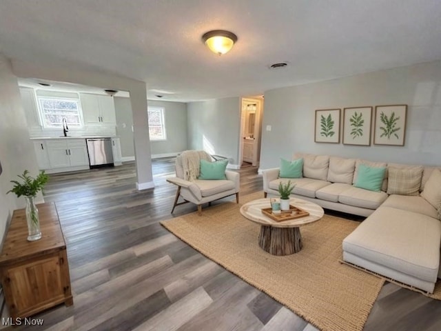 living room featuring dark wood-style floors, visible vents, and baseboards