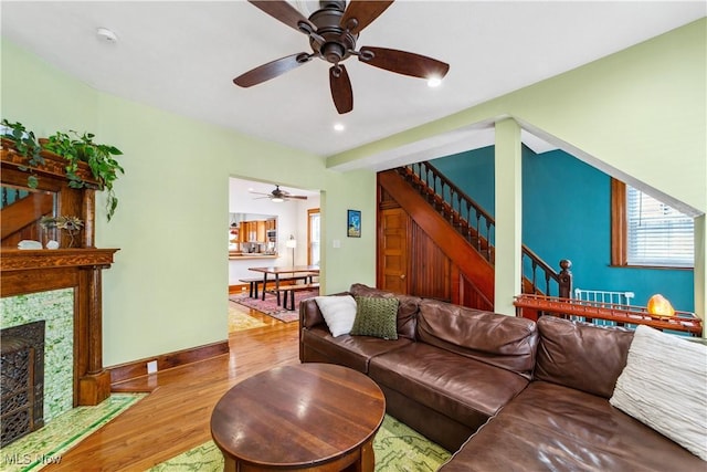 living room with stairs, a tile fireplace, wood finished floors, and a wealth of natural light