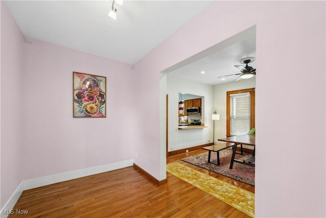 hall with baseboards, wood finished floors, and recessed lighting