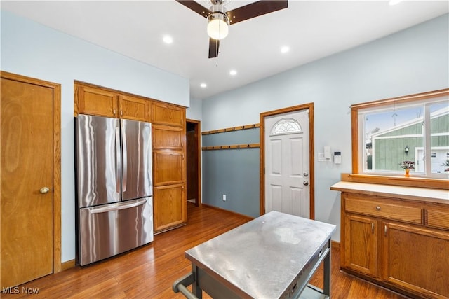 kitchen with dark wood finished floors, light countertops, brown cabinetry, freestanding refrigerator, and a ceiling fan