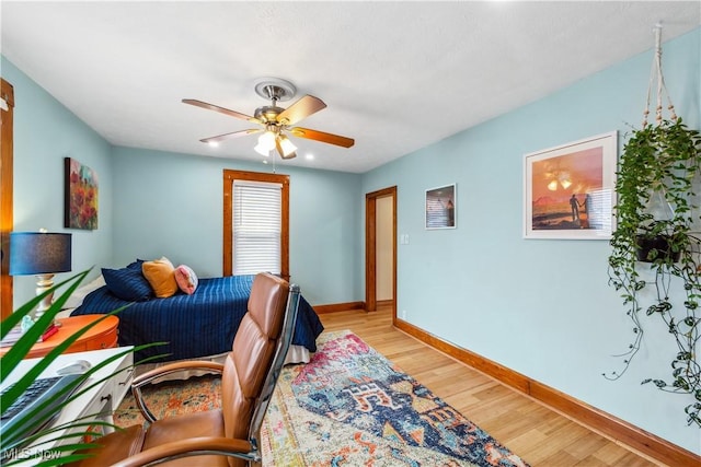 bedroom featuring ceiling fan, light wood-style flooring, and baseboards