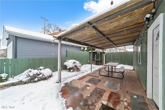 snow covered patio featuring fence private yard