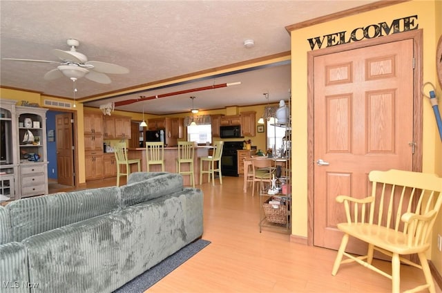 5655 E Windjamer Ave, Lakeside-Marblehead, OH 43440 - living room with a ceiling fan, light wood-style flooring, ornamental molding, and a textured ceiling