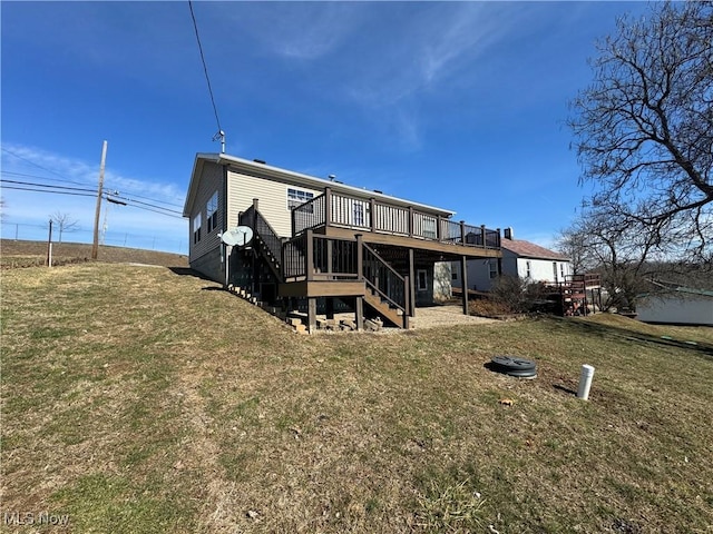 back of property featuring a yard, a wooden deck, and stairs