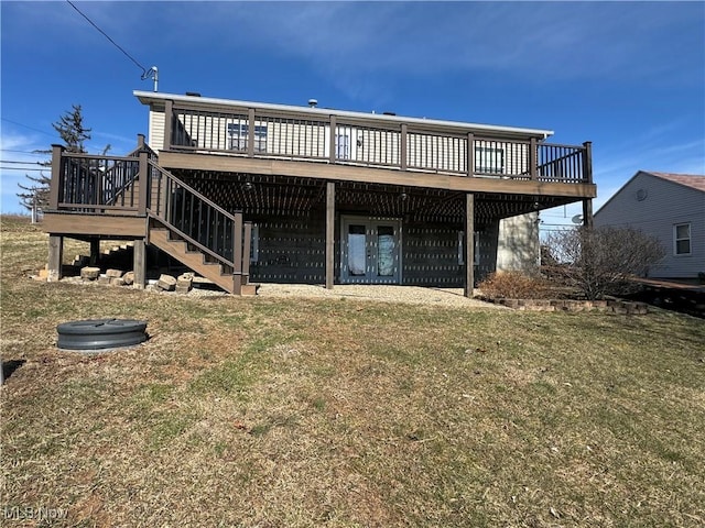 back of property with a deck, a yard, and stairway