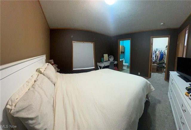 bedroom with a textured ceiling, carpet floors, and lofted ceiling