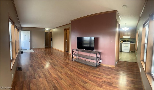 living room featuring baseboards, visible vents, ornamental molding, dark wood-type flooring, and an inviting chandelier