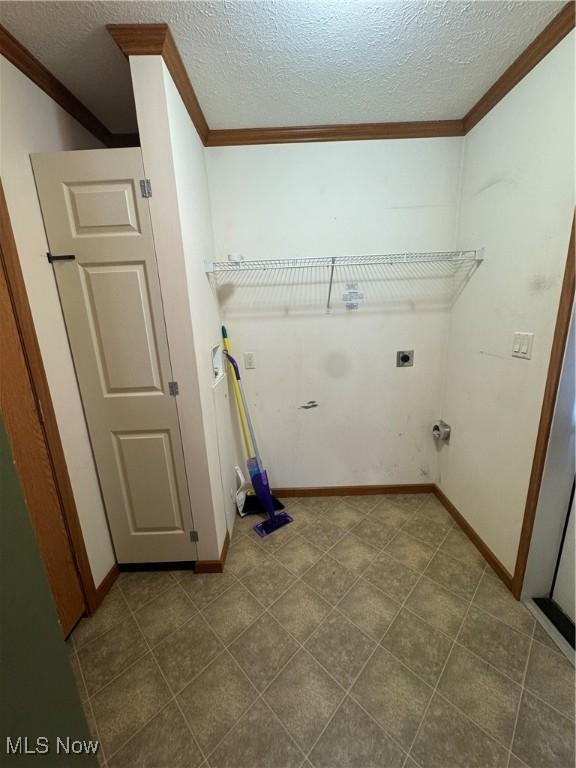 laundry area with a textured ceiling, hookup for an electric dryer, laundry area, baseboards, and ornamental molding