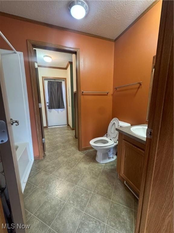 full bathroom featuring toilet, vanity, a textured ceiling, crown molding, and shower / washtub combination