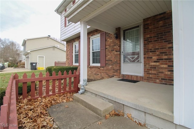 property entrance with covered porch and brick siding