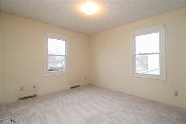 carpeted empty room with visible vents