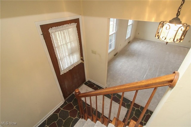 foyer entrance with stairs and carpet floors