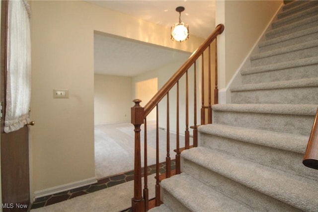 stairway featuring carpet floors and baseboards