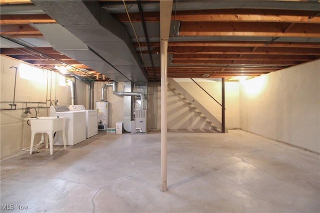 basement featuring gas water heater, heating unit, and separate washer and dryer