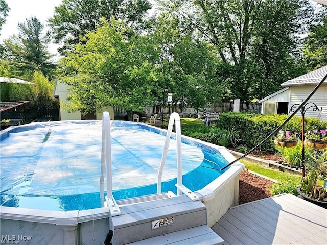 view of swimming pool featuring fence and a deck