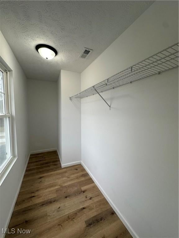 spacious closet with visible vents and wood finished floors